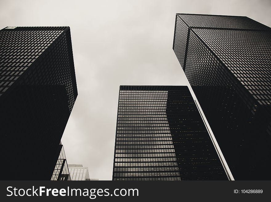 Low Angle Photography of Black High Rise Building Under Nimbus Clouds Background