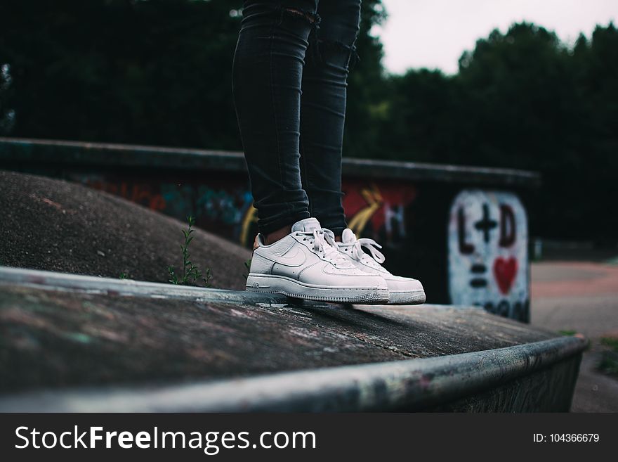 Human Standing on the Ground and Wearing White Nike Sneakers