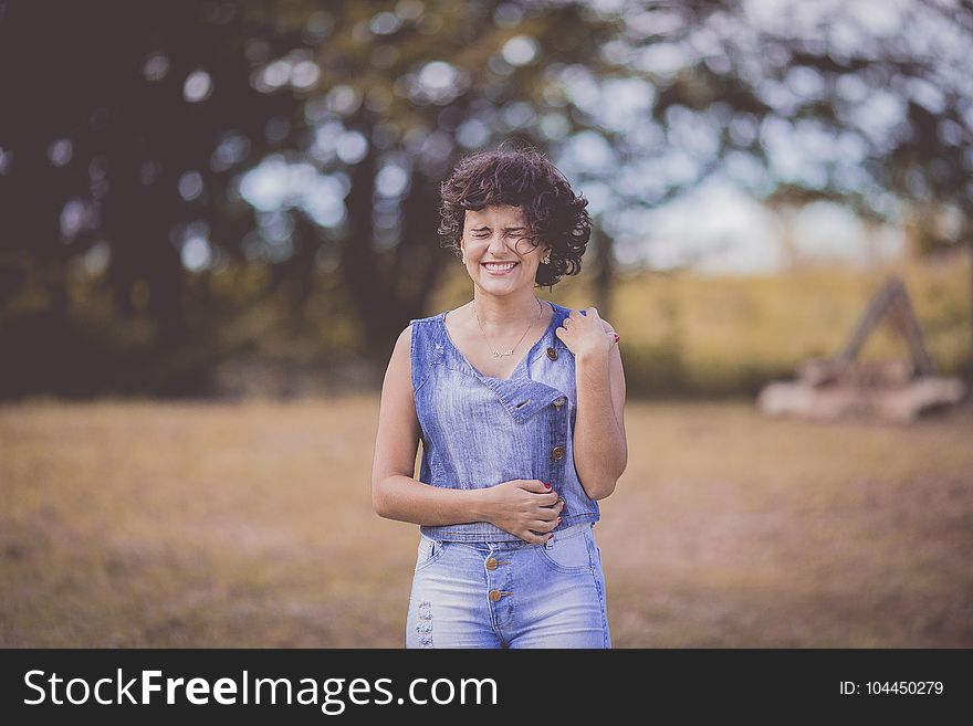 In Distance Woman Wearing Blue Scoop-neck Sleeveless Top And Blue Denim Bottoms