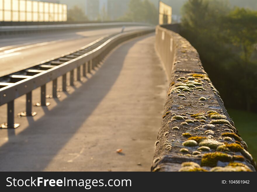 Asphalt pavement highway or road with strong metal german guardrail constructed like on the Autobahn used for fast travelling by cars. Asphalt pavement highway or road with strong metal german guardrail constructed like on the Autobahn used for fast travelling by cars