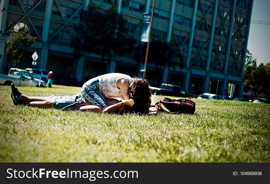 Man and Woman Lying on Green Field