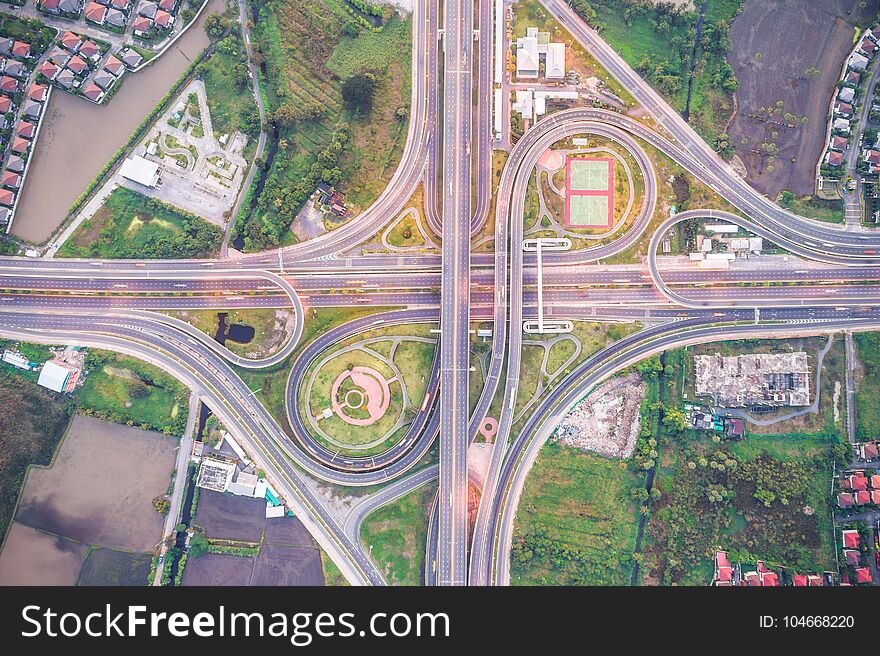 Aerial view of urbal highway intersection road with green exercise background