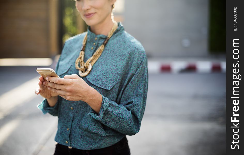 Woman Holding Iphone Wearing Long-sleeved Shirt And Gold Necklace