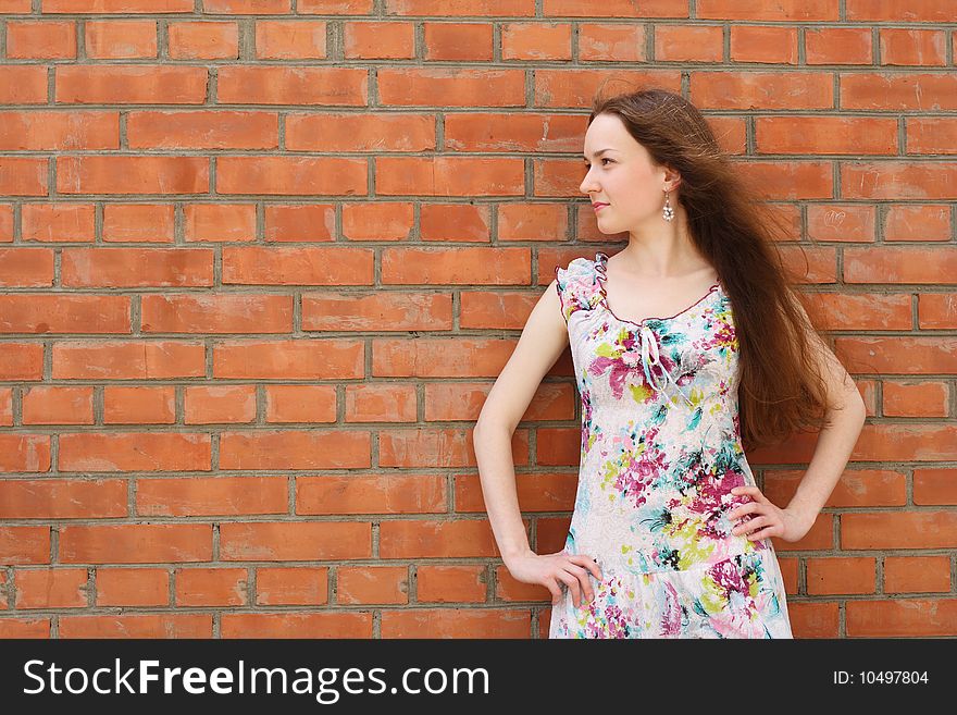 Girl stands near the brick wall. Girl stands near the brick wall