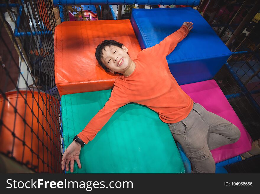 Boy lying on colorful floor at indoor playground