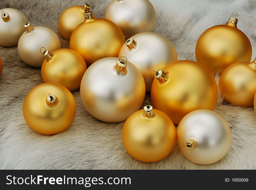 Golden and white Christmas balls on a reindeer fur coat. Golden and white Christmas balls on a reindeer fur coat
