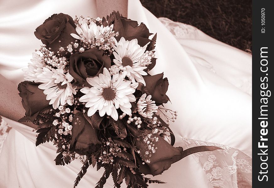 Bride holding her wedding bouquet against her dress