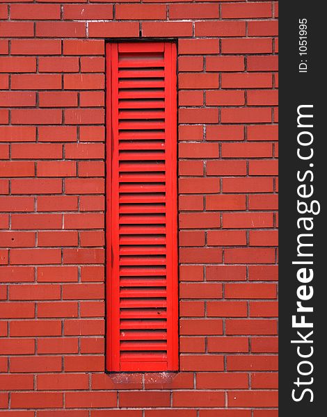 Red vent louver built into red brick wall. Red vent louver built into red brick wall