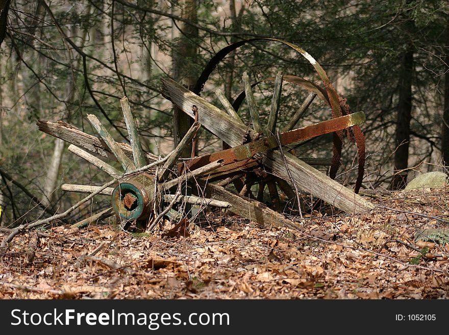 This is a picture of an old, dilapidated cart in the woods. This is a picture of an old, dilapidated cart in the woods.