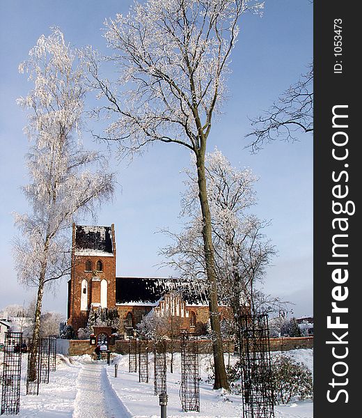 Church  in denmark a sunny winter day with a frozen tree in the  foreground