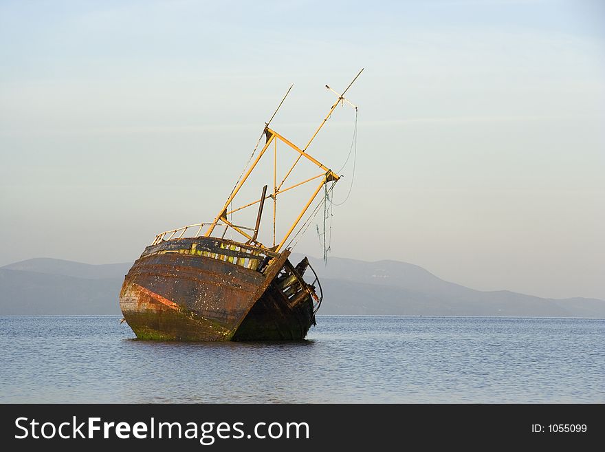 A derelict fishing boat lit by morning sunshine off the coast of Bute. A derelict fishing boat lit by morning sunshine off the coast of Bute