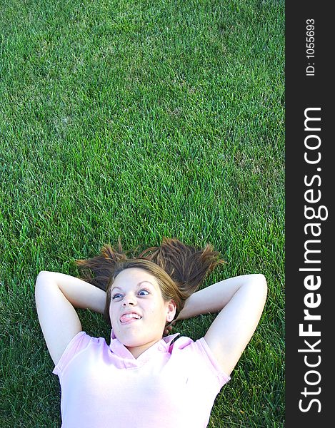 Young woman being silly laying in the grass