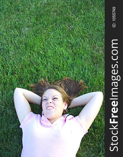 Young woman being silly laying in the grass