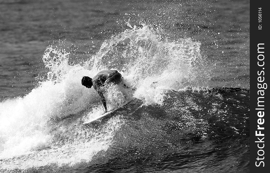 A surfer does a backside spray while surfing in Honolulu, Hawaii. A surfer does a backside spray while surfing in Honolulu, Hawaii.