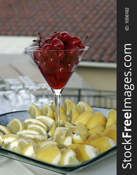 Cherries and lemons in glass on a bar, with shallow DOF