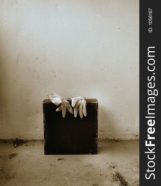 A photo of a pair of latex gloves on a black paper box slightly enhanced to look eerie. A photo of a pair of latex gloves on a black paper box slightly enhanced to look eerie