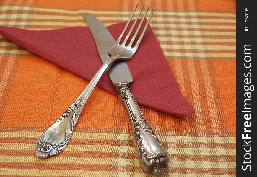 Plug, knife and red napkin on a cloth. Plug, knife and red napkin on a cloth