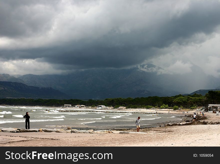 Corsica   Bay of Calvi, people on the beach before the storm,. Corsica   Bay of Calvi, people on the beach before the storm,