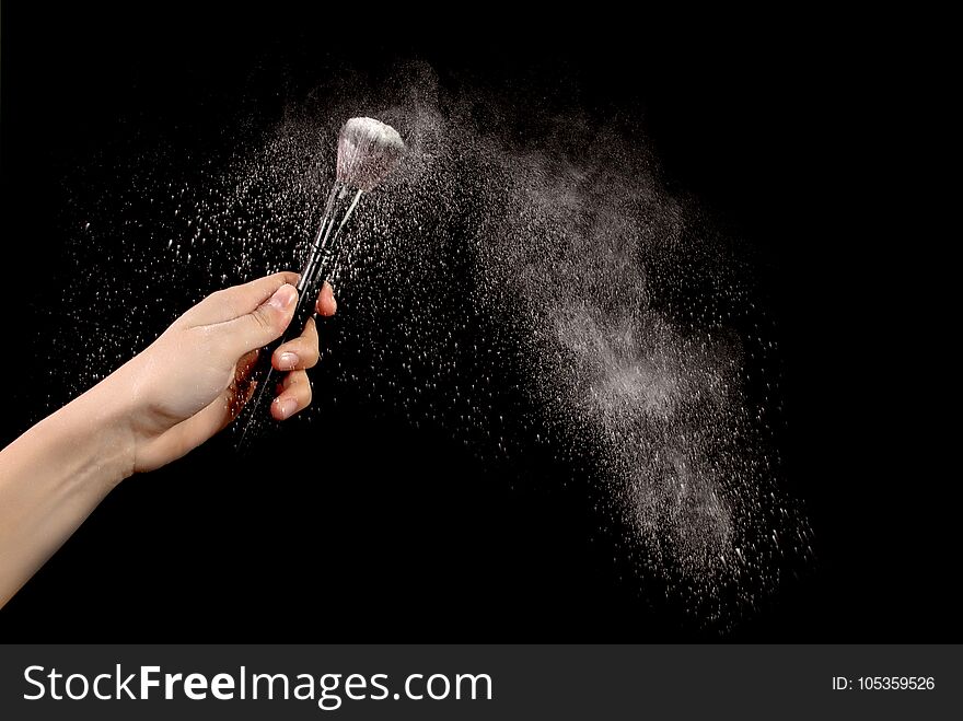 White blusher explosion in woman hand on black beckground