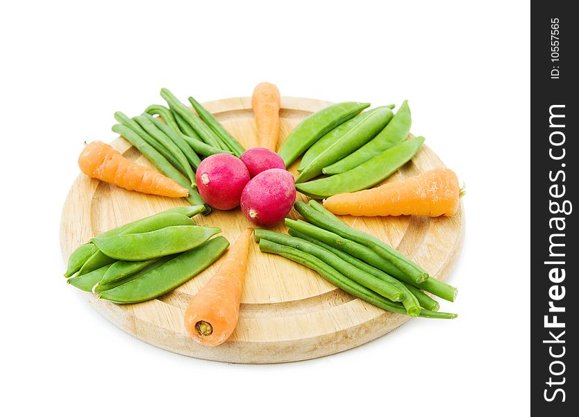 Healthy eating - mix of fresh baby vegetables on a round chopping board. Isolated on white. Healthy eating - mix of fresh baby vegetables on a round chopping board. Isolated on white.