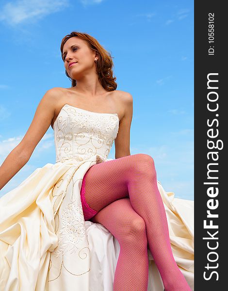 Woman in a wedding dress on a background of the sky