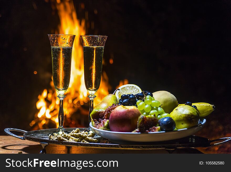 Still life with champagne on the background of camp fire