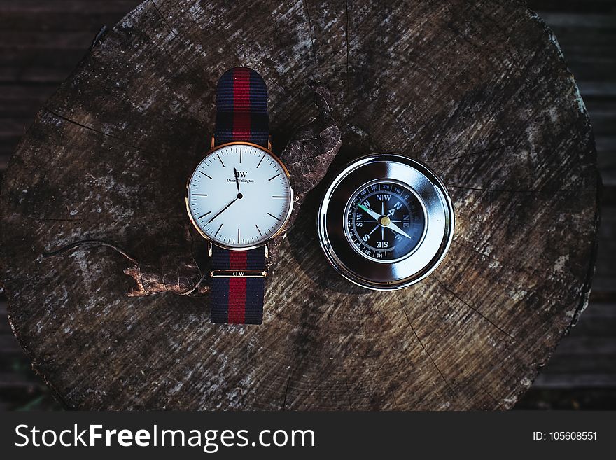 Round Silver-colored Analog Watch Beside Compass