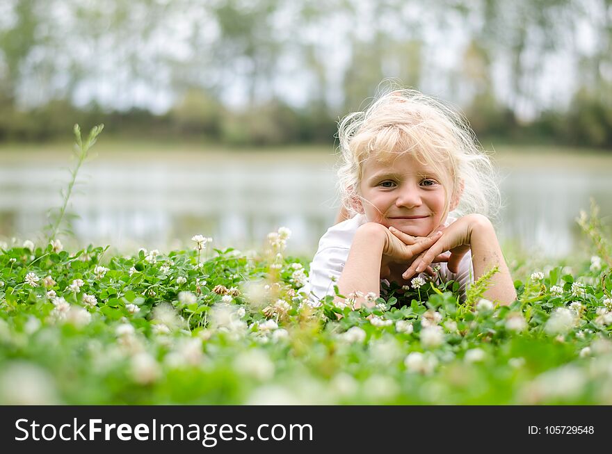 Little lovely girl lying on the grass and enjoying life. Little lovely girl lying on the grass and enjoying life