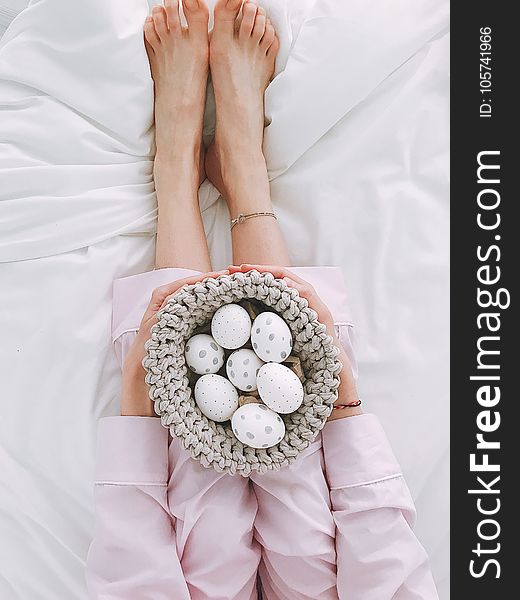 Woman Holding Gray Crochet Bowl With Seven Painted Eggs