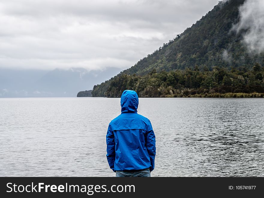 Person Wearing Blue Hoodie Near Body of Water