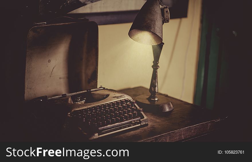 Sephia Photography of Desk Lamp Lightened the Gray Typewriter on Wooden Table