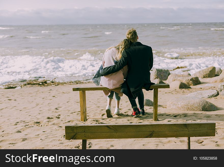 Man and Woman Hugging and Sitting on a Bench
