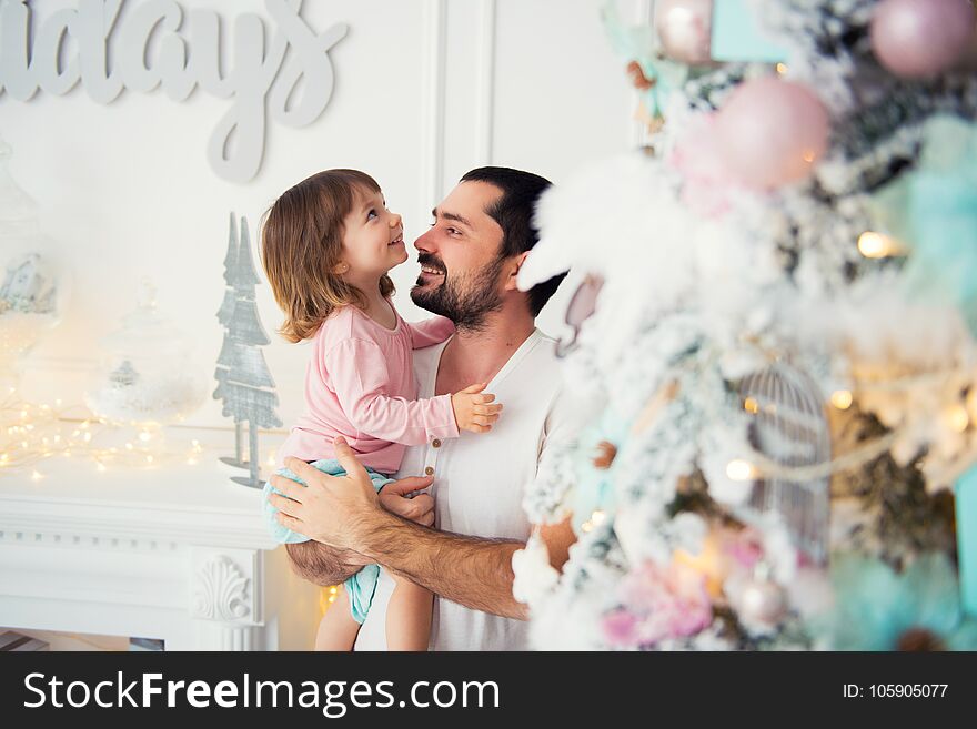 Little daughter and father near Christmas tree. Happy New Year