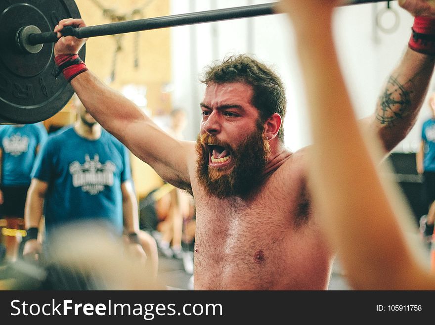 Man Carrying Black Barbell