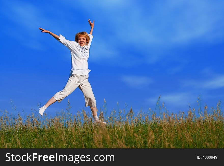 Beauty girl in field under clouds