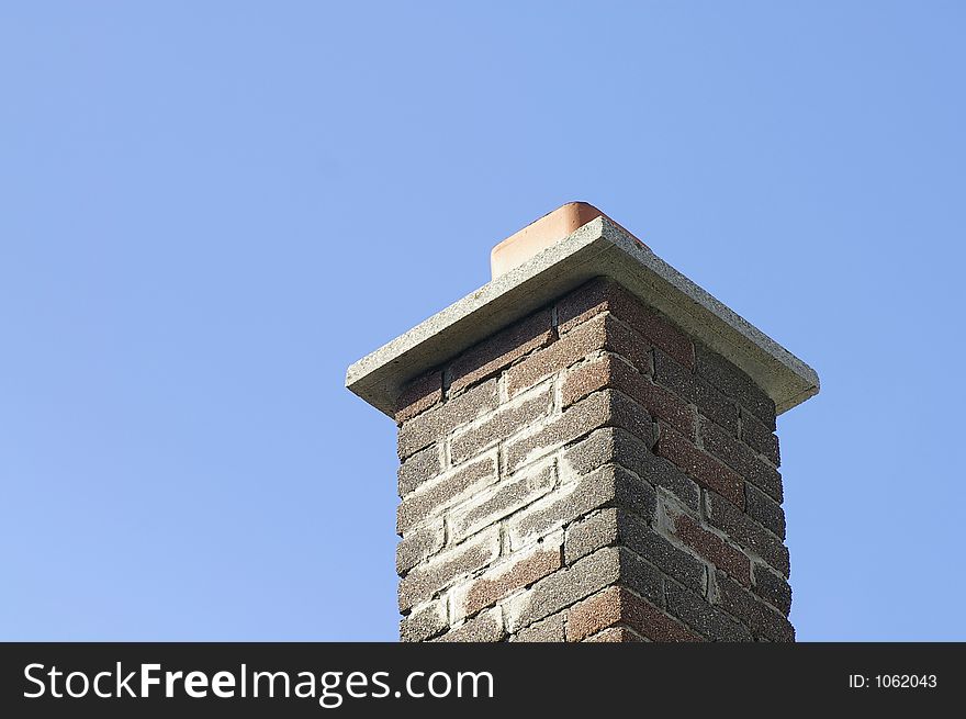 Multi Brown Brick Chimney Against a Blue Sky Background