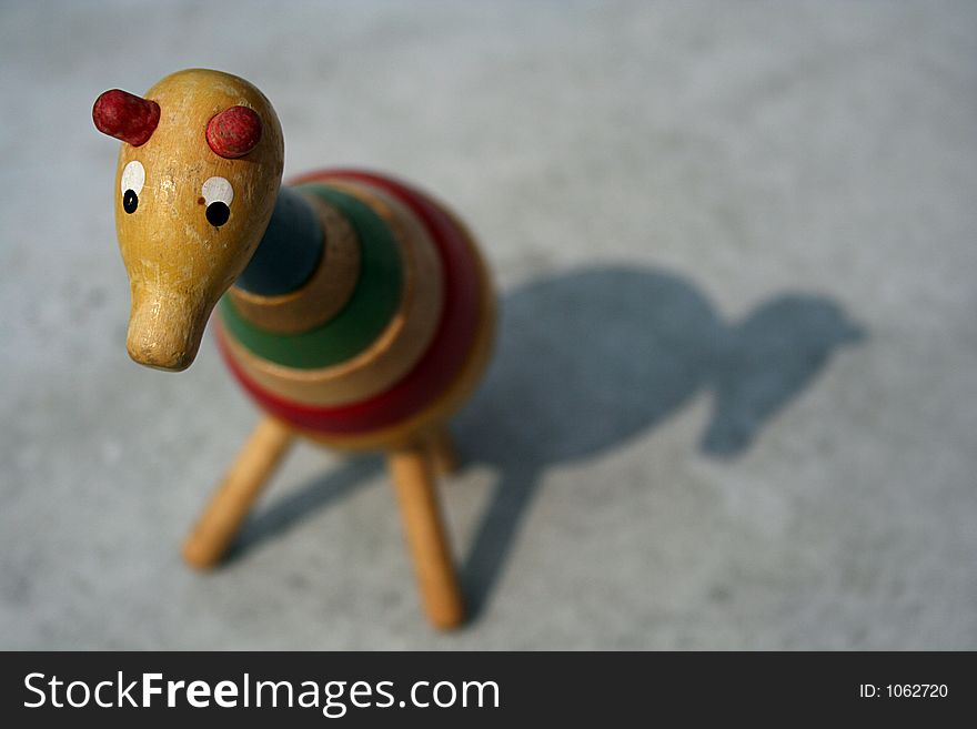 An adorable (and somewhat sad-looking), little toy giraffe with a shallow depth of field.