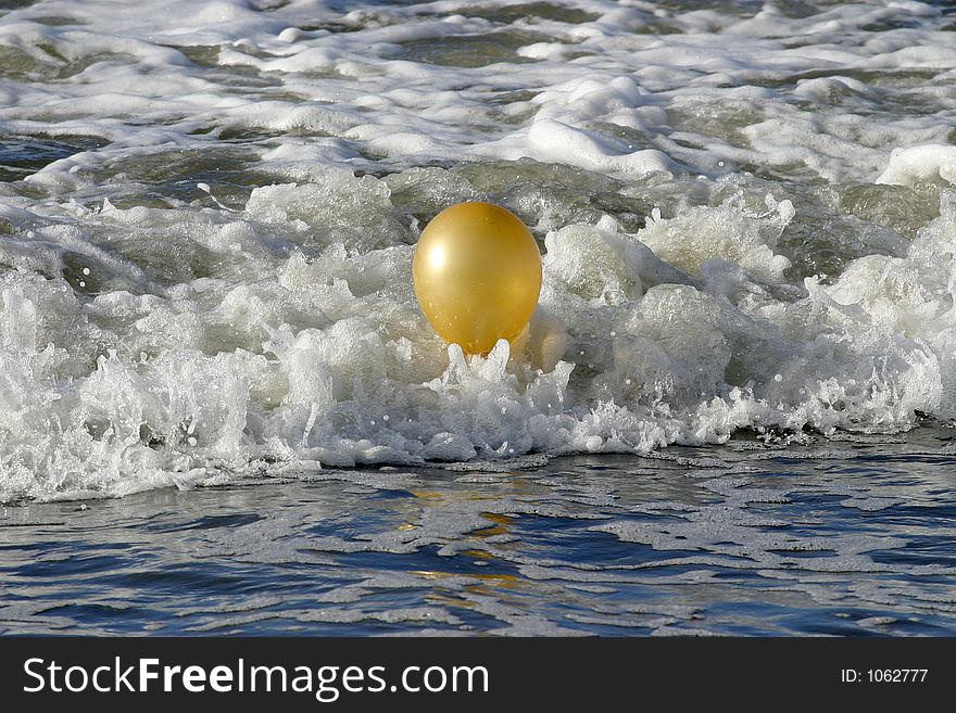 Golden Baloon bouncing in the waves could indicate success or trapped by success. Golden Baloon bouncing in the waves could indicate success or trapped by success