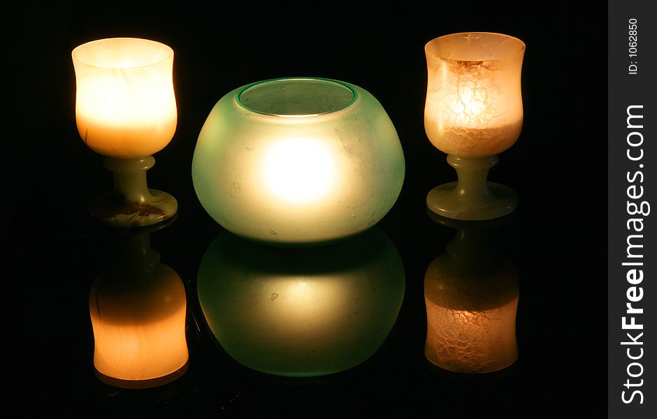 Cups and candles, black background. Cups and candles, black background