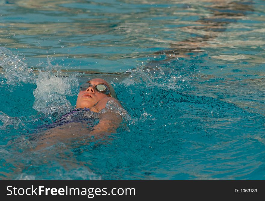 Teen doing backstroke in swimming competition. Teen doing backstroke in swimming competition
