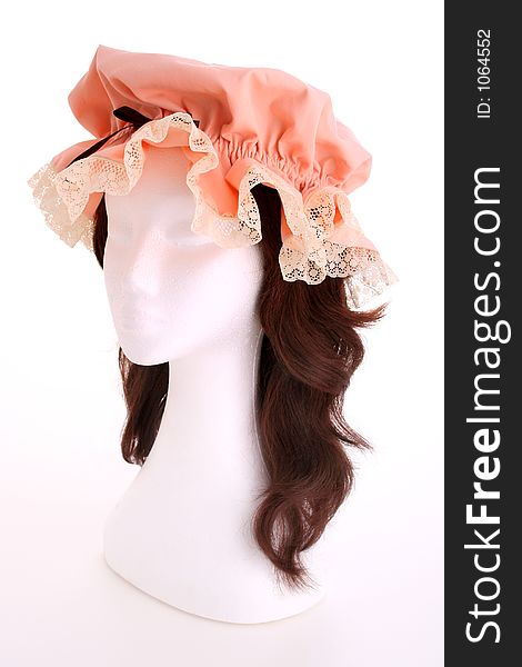 A ladies apricot bonnet with lace trim taken on a white mannequin head