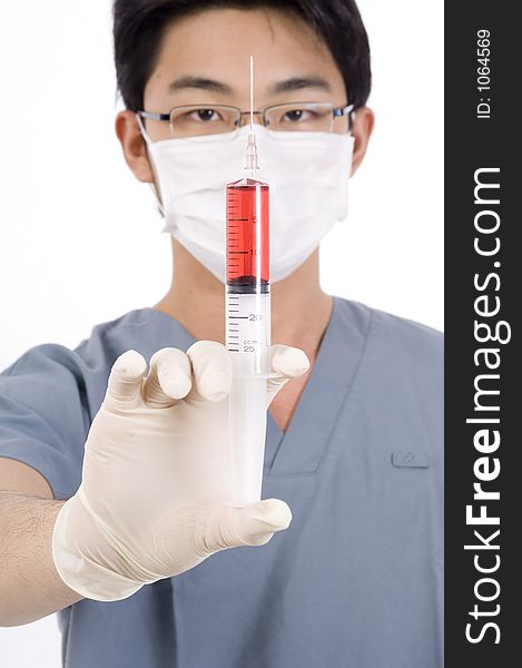 A young doctor holds a syringe of red liquid. A young doctor holds a syringe of red liquid