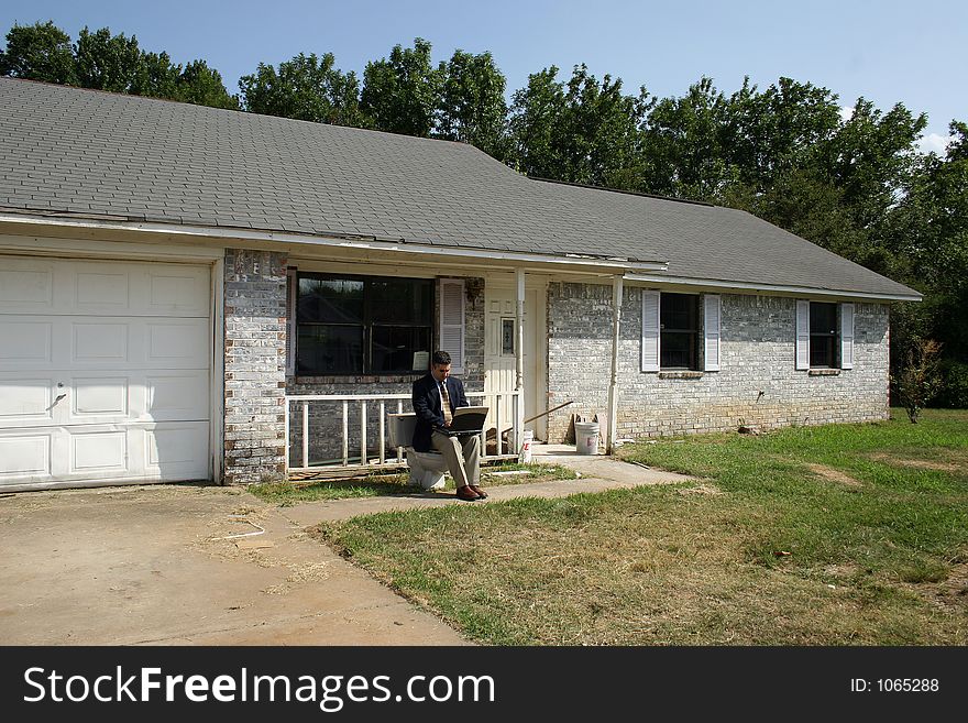 Man in suit with laptop sitting on toliet outside home. Man in suit with laptop sitting on toliet outside home.