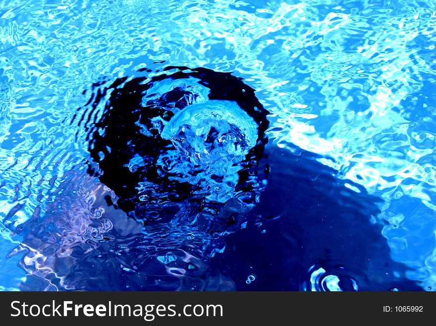 Kid in underwater in a blue pool.