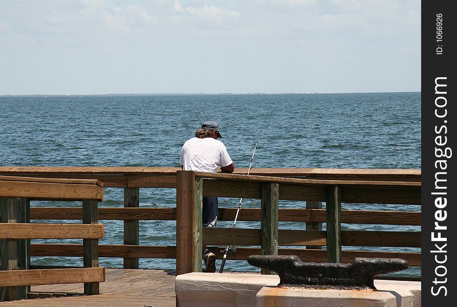 Lonely fisherman waiting for a catch. Lonely fisherman waiting for a catch.