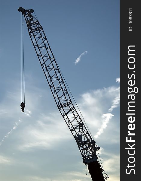 Construction crane against blue cloudy sky