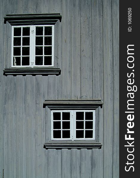 Two windows on a gray, wooden wall. Two windows on a gray, wooden wall