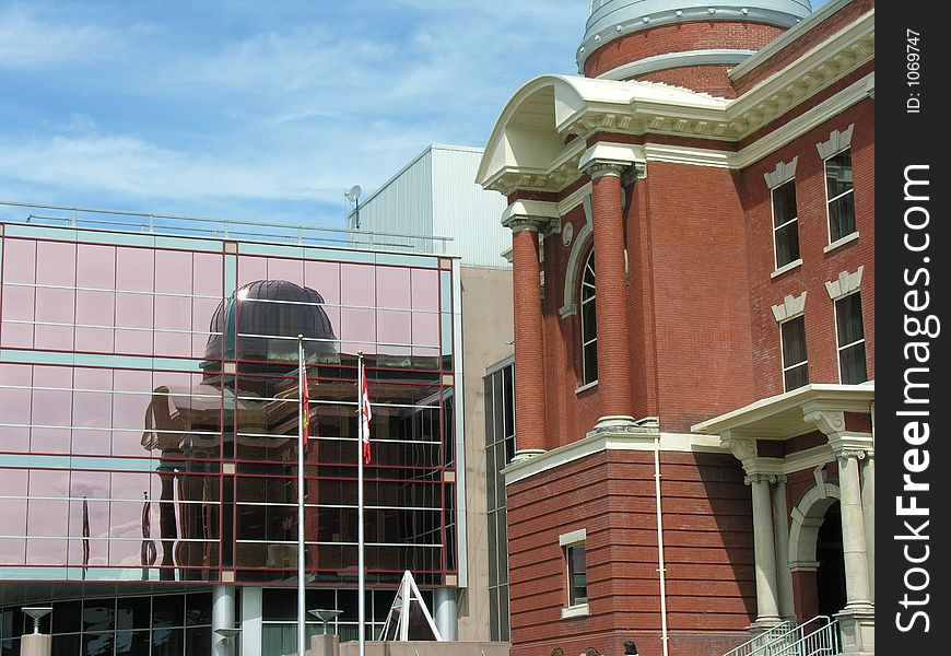 Old historic building reflected in new modern glass building. Old historic building reflected in new modern glass building