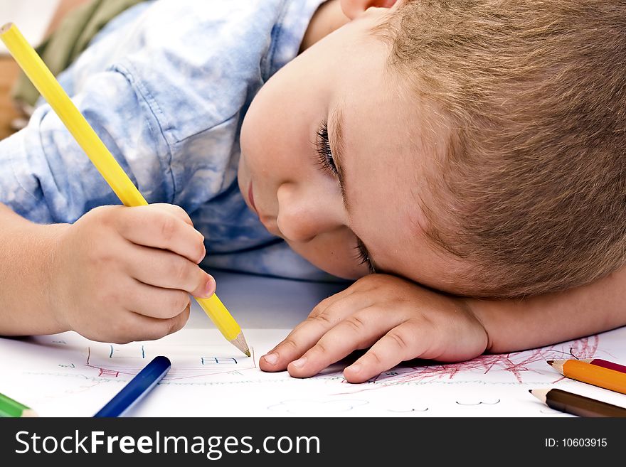 Adorable little boy drawing whit colored pencil