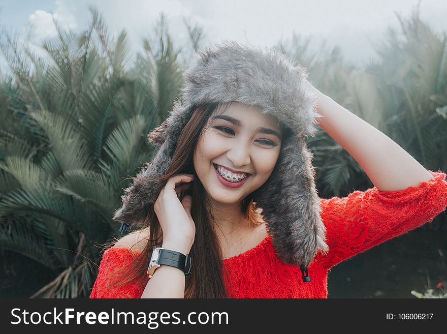 Woman In Red Off Shoulder Top Wearing Fur Beanie Smiling for Photo